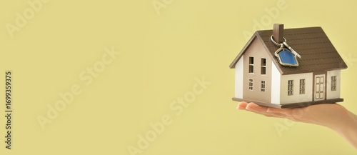 Hand holding house model an...