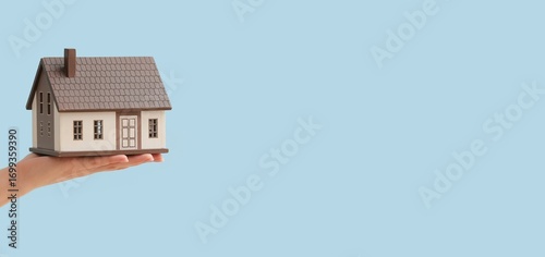 Hand holding house model on...