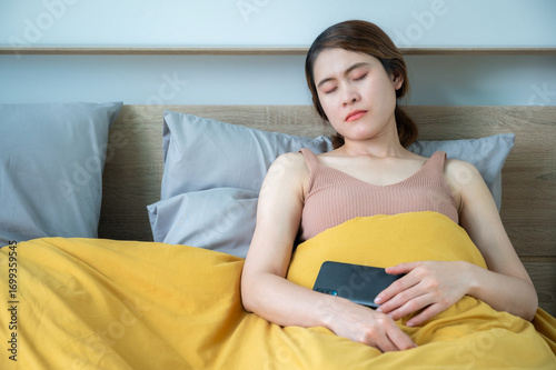 Young Asian woman fell asleep during using smart phone. Fell asleep is the most common and idiomatic way of expressing the action of falling asleep.