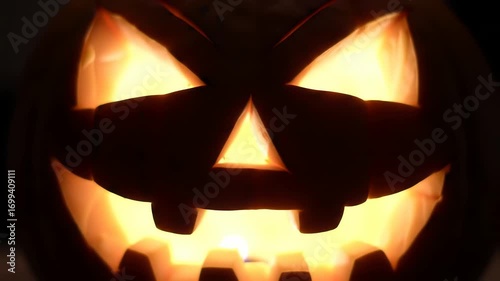 Closeup of a Carved Jack-O-Lantern with Illuminated Face for Halloween Decorations