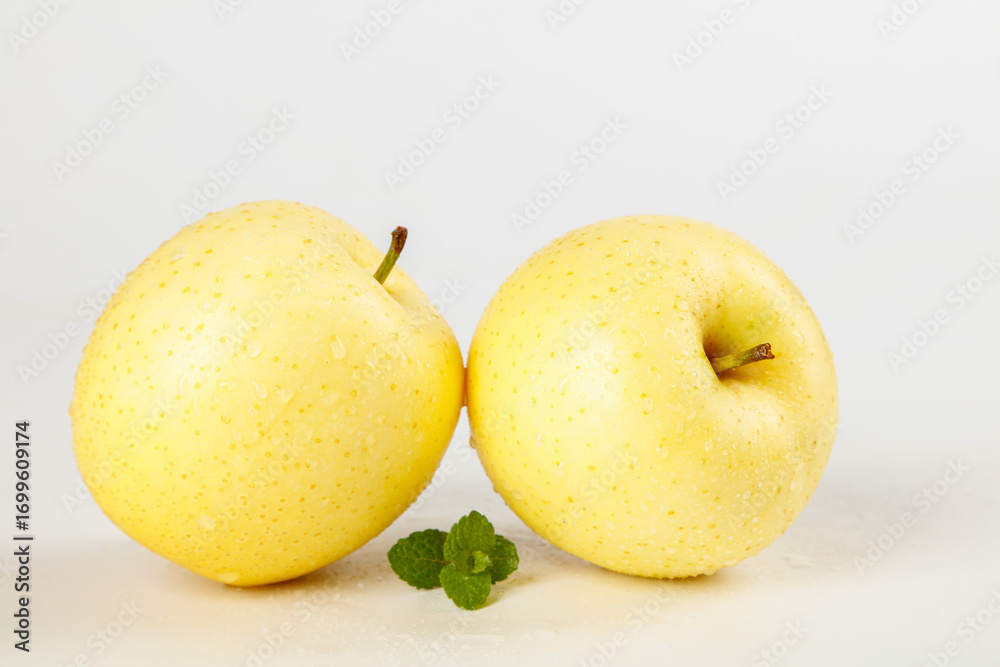 Fototapeta premium Fresh Golden Yellow Apples with Mint Leaves on White Background