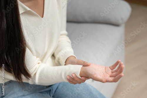 Bild auf Leinwand young woman working in office with a carpal tunnel syndrome or wrist joint infla