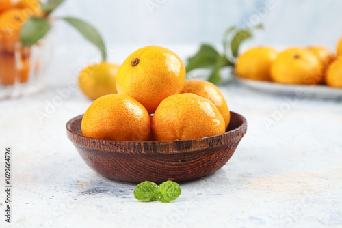 Fotografía Fresh Small Orange Citrus Fruits in Wooden Bowl - Healthy Seedless Sugarplum Var