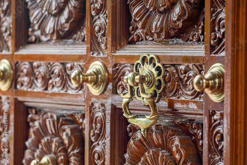 Decorated antique door knocker in hindu temple door	
