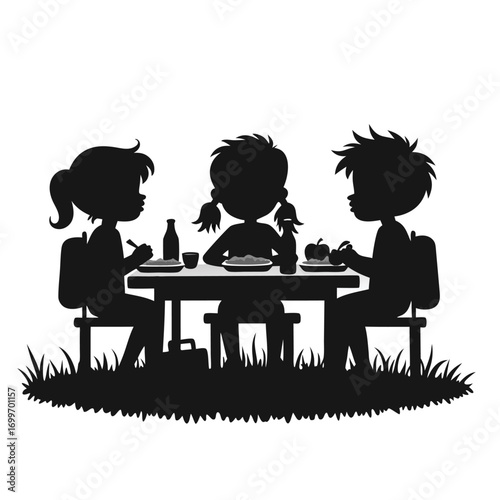 Children eating lunch at a picnic table silhouette