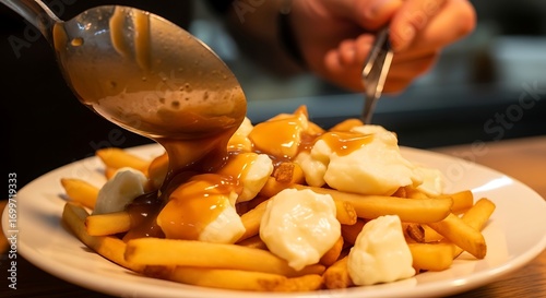 Food preparation of poutine with cheese curds melting on fries