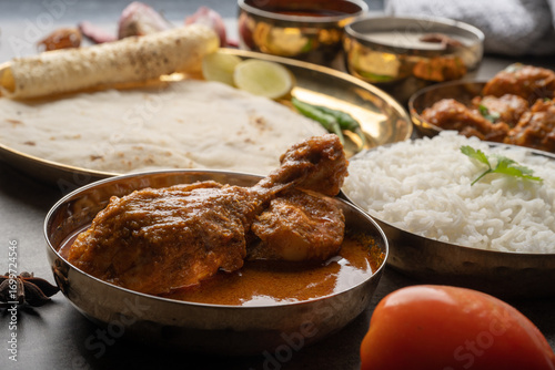 Kolhapuri chicken Thali is a popular Indian asian food platter consists of poultry meat, chikan sukka bhakri, rice, salad tambda padhra rassa 