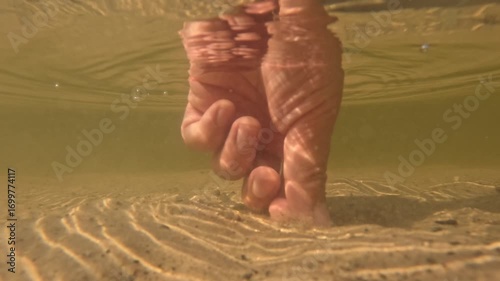 Hand reaching for something lost in the murky water