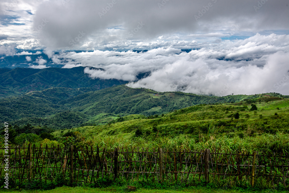 Fototapeta premium The natural background of the sky above several large mountains, with a view of clouds, trees, mist and a cool breeze blowing throughout the journey.