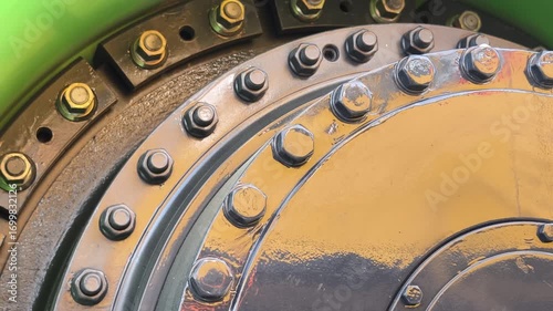 Close-up view of large industrial machinery showcasing bolts and metal components in a factory environment