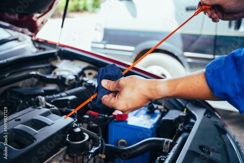 technician changing engine oil and performing vehicle service in a garage, professional auto mechanic work, tools and car parts, clean and organized workshop
