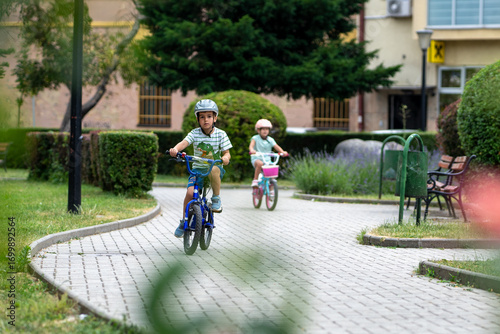 Wallpaper Mural Two confident youngsters enjoy a bike ride in the city, showcasing their friendship and joy. The image highlights health and the importance of safety measures like wearing helmets.  Torontodigital.ca
