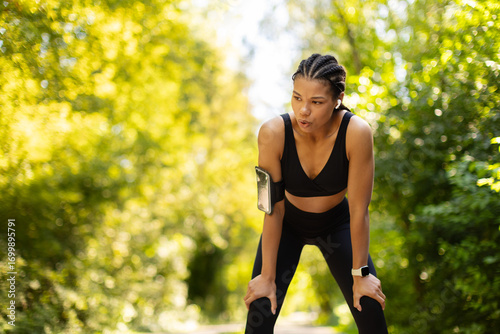 Quadro su tela Tired but determined African American woman catching breath after running outdoors