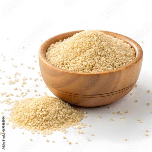 Fonio grains in a wooden bowl, isolated on white background, highlighting their tiny size, light color,