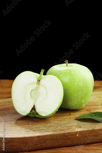 Foto Fresh Green Apples from Shaanxi China on Wooden Board - Whole and Sliced Fruit w