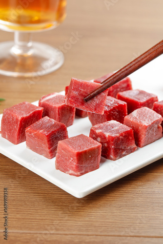 Fresh Diced Raw Beef Cubes from Australia on White Plate with Chopsticks - Premium Quality Meat for Cooking