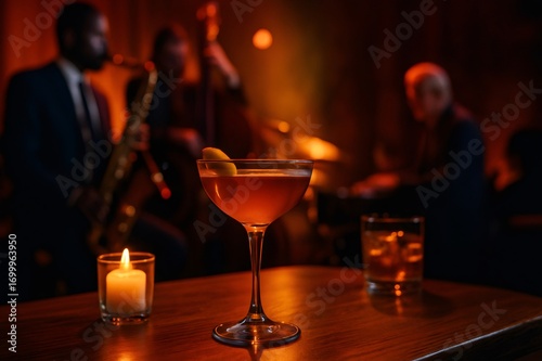 Cocktail glass and candle burning on table in jazz club with musicians playing in background