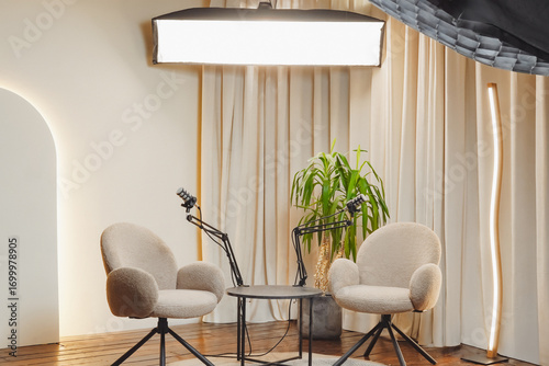 Modern podcasting setup with microphones and cozy chairs in a well-lit studio environment