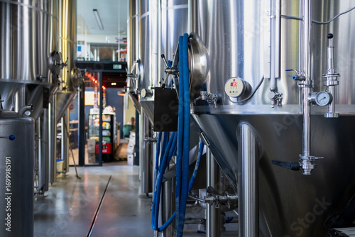 фотографія stainless steel beer brewing tanks inside modern brewery, industrial fermentatio