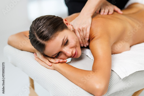 Spa therapy. Beautiful young woman lying on table during massage in salon, closeup