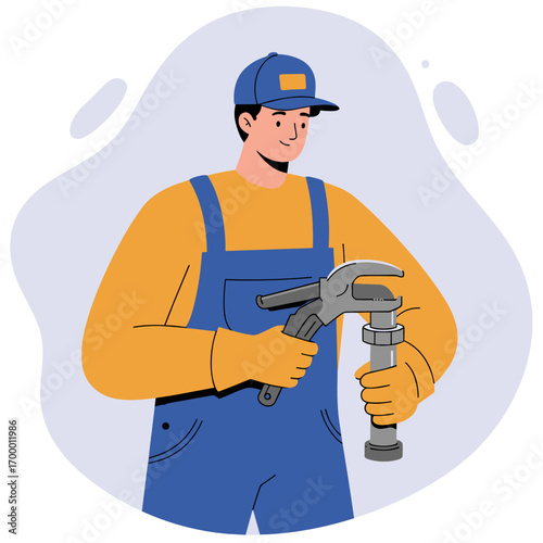 Young man in blue overalls holding a wrench and pipe fitting  