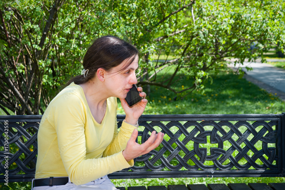 Naklejka premium Young girl speaking by phone