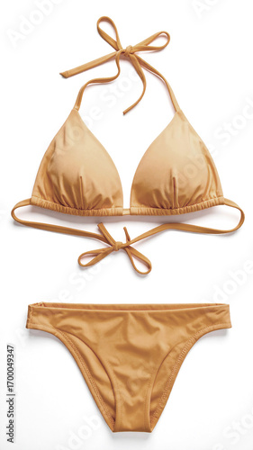 Elegant gold bikini lying on white background is ready for summer vacation