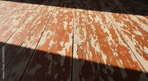 Weathered wooden planks with peeling red paint and dappled sunlight