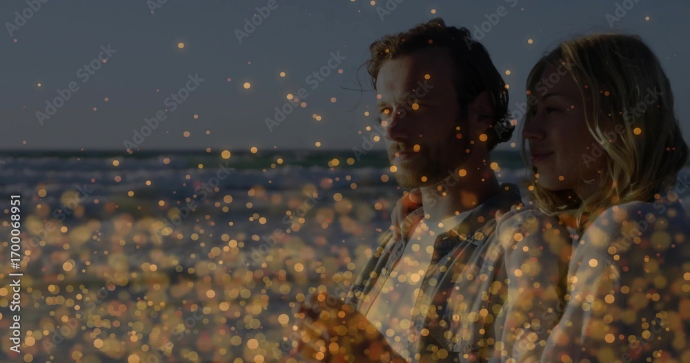 Fototapeta premium Standing couple gazing on sandy beach at dusk, with golden bokeh lights, copy space