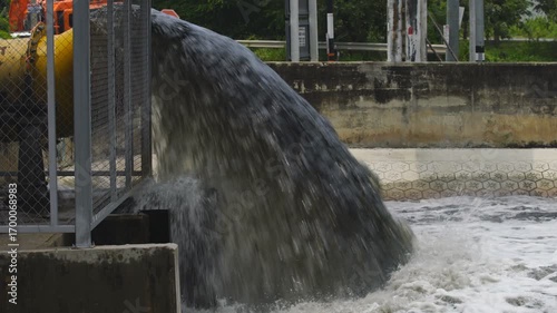 Water flowing from pipe into wastewater treatment plant environment