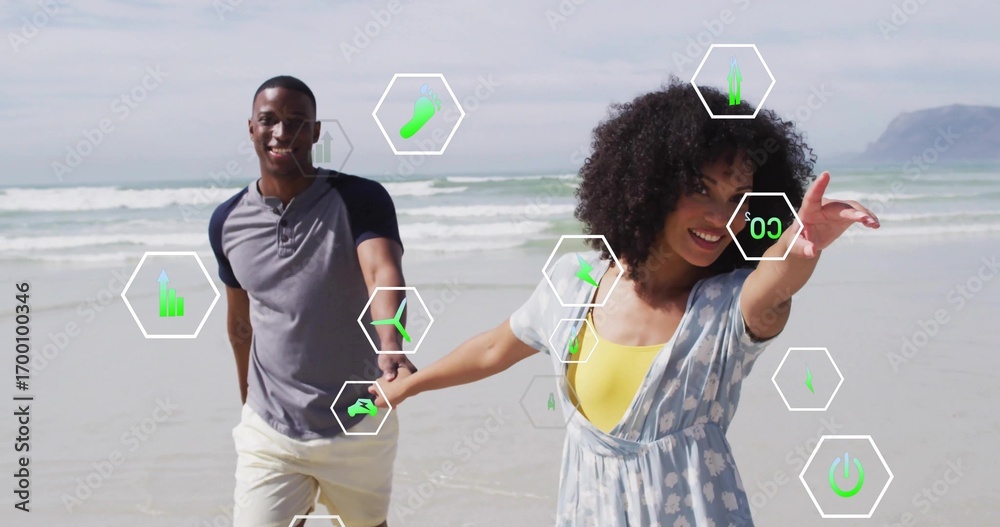 Naklejka premium Running couple holding hands along wet sand at beach shoreline, with hexagonal graphic overlays