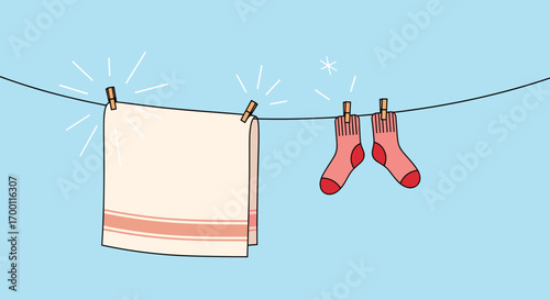 Freshly washed towel and socks drying on a clothesline under a clear blue sky