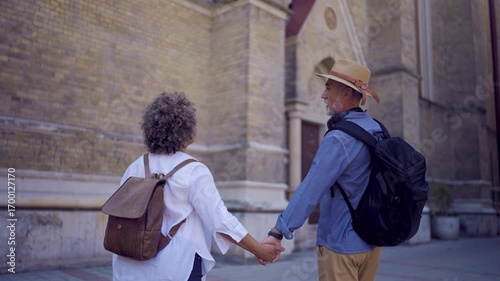 A middle-aged couple explores a beautiful city, enjoying the sights, local culture, and charming streets.
