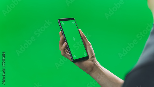 Cuadro en lienzo Close Up of Hands Holding a Smartphone Device with a Blank Green Screen Mock Up