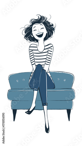 A cheerful woman with short, wavy hair sits on a blue couch, dressed in a striped top and casual jeans while smiling. Her expressive demeanor radiates happiness.