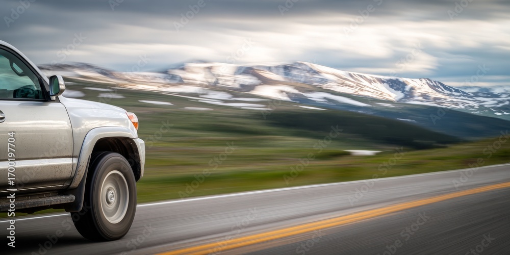 Fototapeta premium Silver suv driving on scenic mountain highway in summer