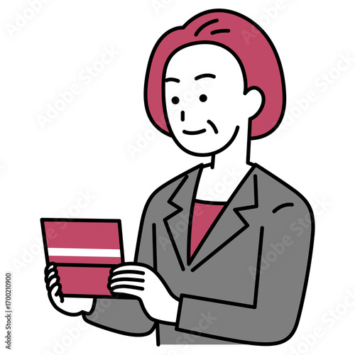 預金通帳を見る中年のスーツの女性