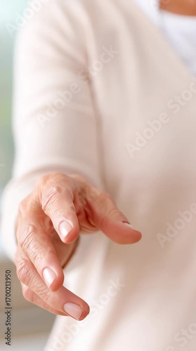 Elderly woman's hand holding and showing house keys for property ownership, moving, or real estate footage.