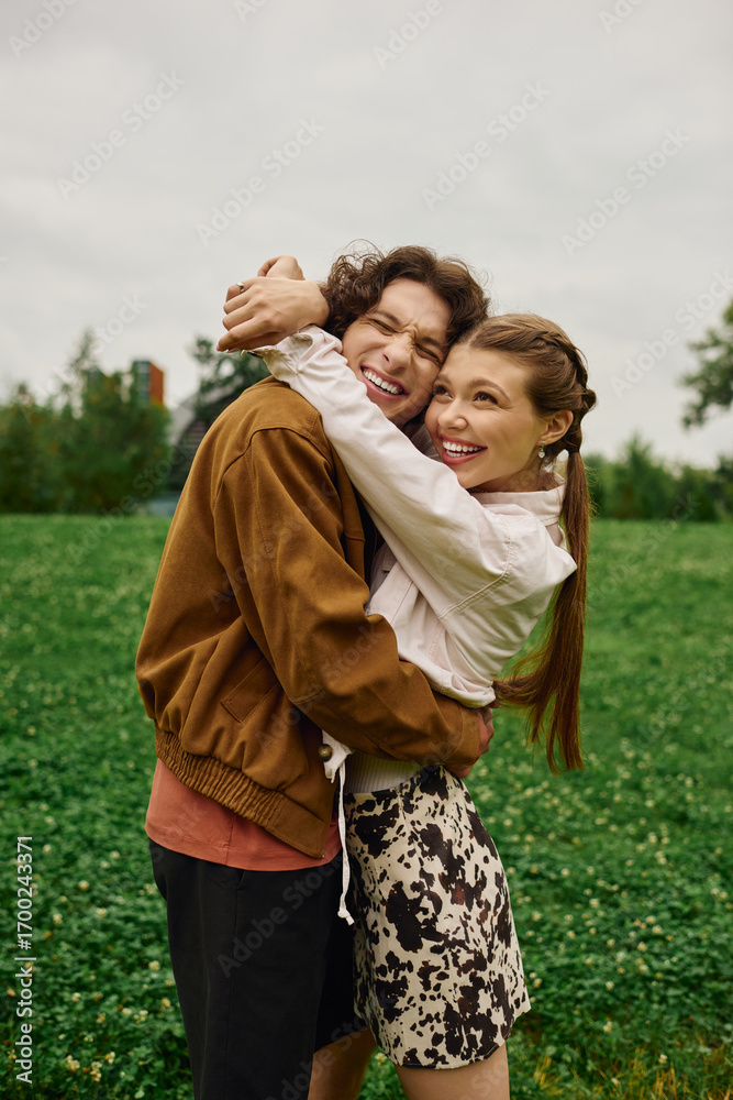 Fototapeta premium Joyful couple enjoys a romantic walk in the park surrounded by natures beauty