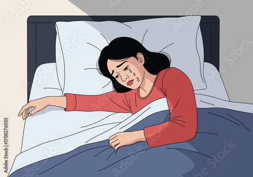 A young woman crying in bed feeling sadness and despair