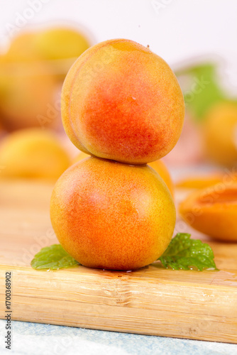Fresh Xinjiang Apricots with Mint Leaves on Wooden Board - Healthy Organic Fruit Background