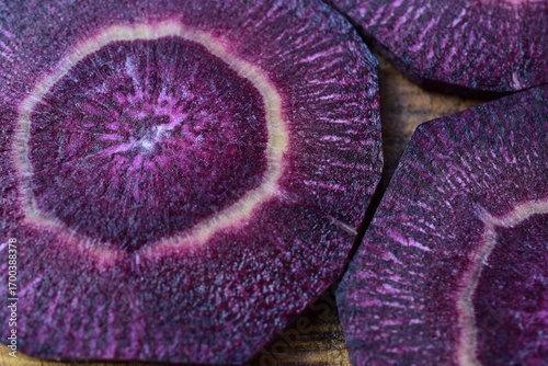Violette Karotten im Querschnitt mit vielfältiger Textur als Hintergrund für gesunde Ernährung