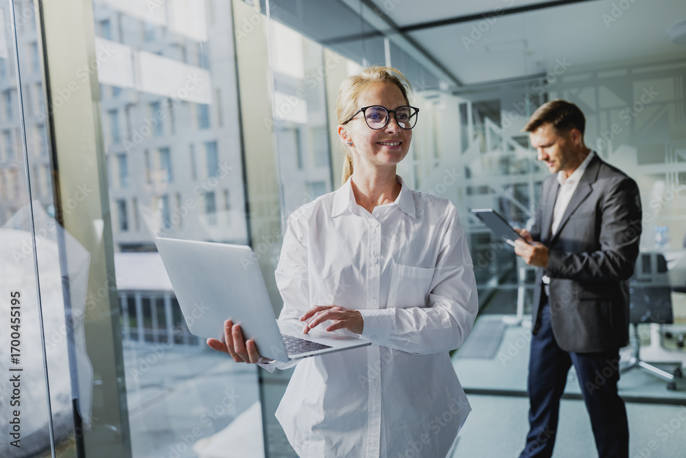 Fototapeta premium Professional individuals collaborating in a modern office setting while using technology