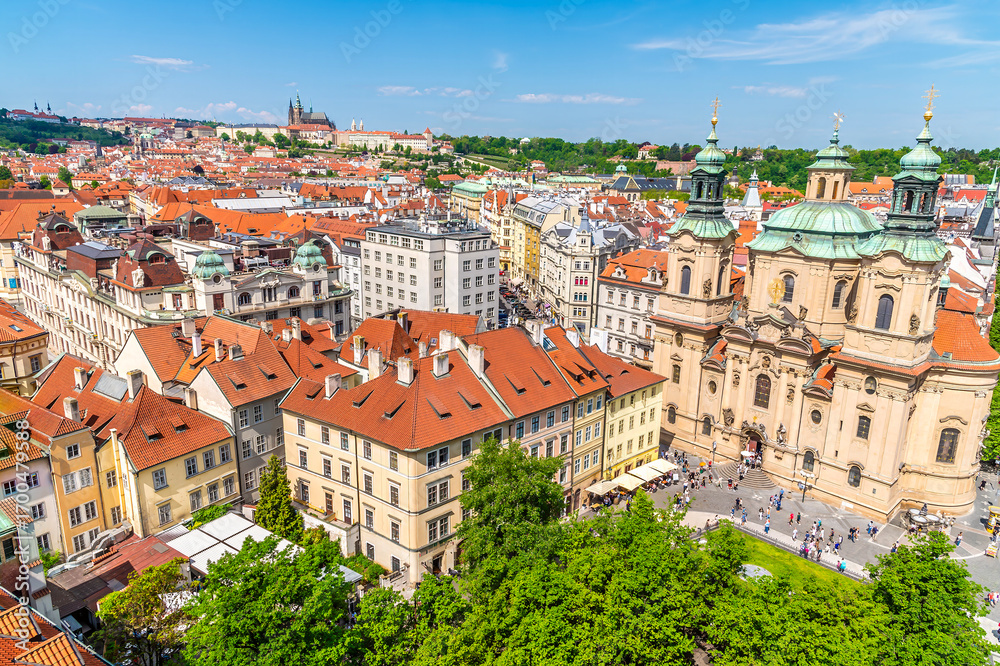 Obraz premium An aerial view north west past rooftops from the City Hall tower in the old town square in central Prague in springtime