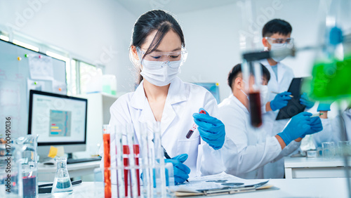 Scientists working together in a modern laboratory analyzing blood samples, highlighting medical diagnostics, healthcare research, teamwork, diversity, and scientific empowerment.