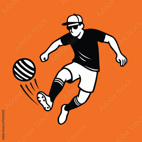 A soccer player in black clothing kicks a striped ball The background is orange