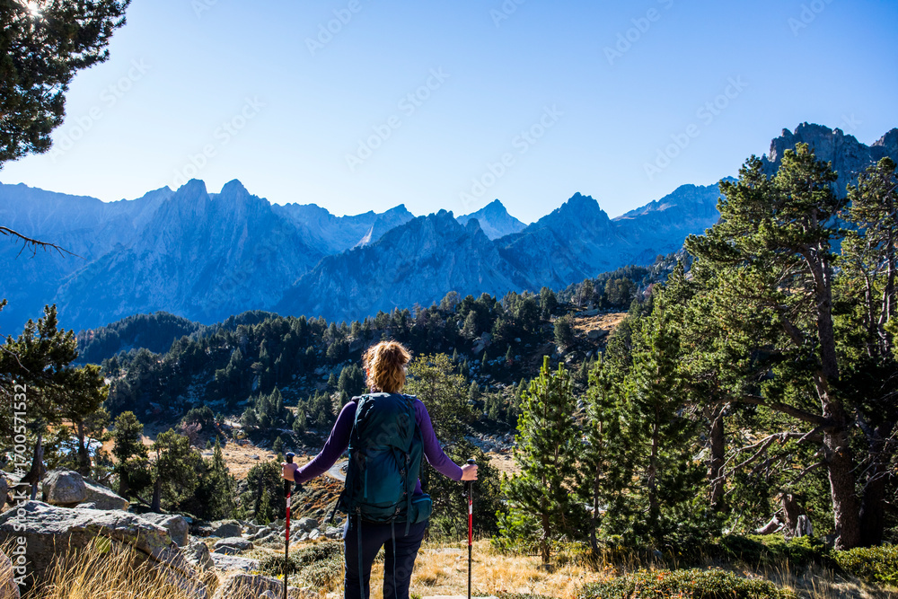 Naklejka premium Young hiker woman in autumn in Aiguestortes and Sant Maurici National Park, Spain