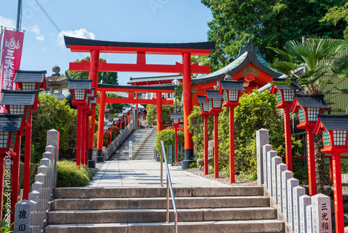 Fotografie Inuyama, Aichi, Japan - July 22 2024 : The front entrance approach and stone steps of Sanko Inari Shrine
