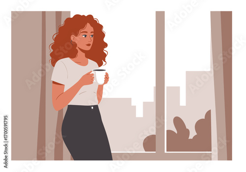 Woman with curly red hair holding a mug standing by a window overlooking a city