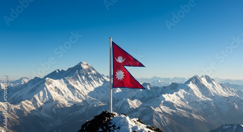 A Nepali flag flutters atop a snow-covered mountain peak against a backdrop of stunning Himalayan vistas